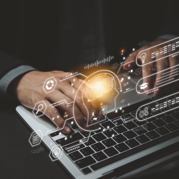 A person typing on a laptop, surrounded by glowing icons representing technology, ideas, and artificial intelligence.